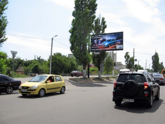 Фото рекламной плоскости по адресу Павлова Ак. ул., 112, (на светофоре), (ТЦ "Барабашово", шиномонтаж, 300м. к ст. м .Академика Барабашова, Дисконт-Центр Adidas/Reebok), направл. в центр