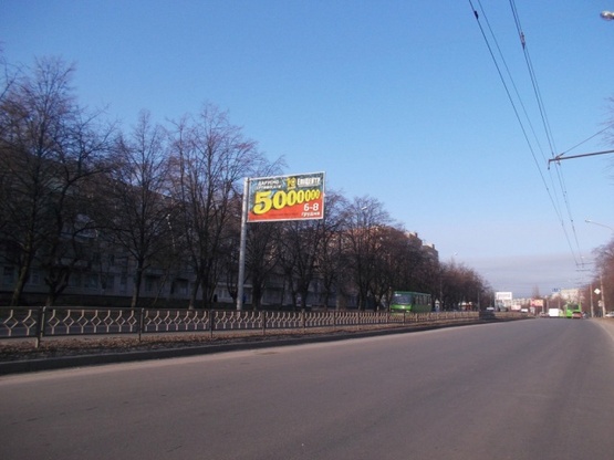 Фото рекламной плоскости по адресу Юбилейный просп. 76 (50-ти летия ВЛКСМ просп), (детская поликлиника №7, ОщадБанк, кафе "Мартекс", Аптека "Низких цен", "911"), в сторону просп. Тракторостроителей