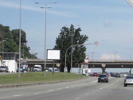 Фото рекламной плоскости по адресу Набережне шосе, 25 (розподілювач біля мосту Метро) за 100 метрів по ходу до мосту Метро