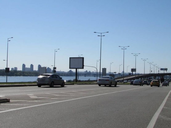 Фото рекламной плоскости по адресу Набережне шосе, 25 (розподілювач біля мосту Метро) після 100 метрів по ходу від мосту Метро