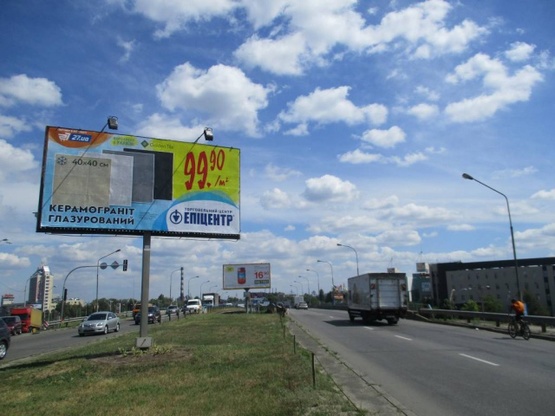 Фото рекламної площини за адресою Богатырская ул., разделитель / на мосту  по ходу на  проспект Степана Бандеры (Московский)