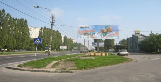 Фото рекламной плоскости по адресу м. Рівне вул. Шухевича 12, навпроти автозаправки “OKKO” та перехресті вулиць Шехевича/Андрія Мельника, неподалік офісний центр